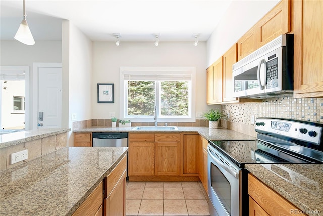 2800 Aurora Ave Unit 121, Boulder, CO 80303 - kitchen with appliances with stainless steel finishes, decorative backsplash, light tile patterned floors, hanging light fixtures, and light stone countertops