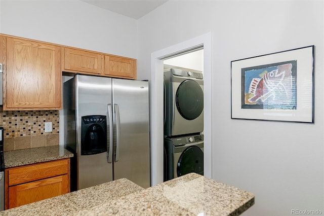 2800 Aurora Ave Unit 121, Boulder, CO 80303 - kitchen with stainless steel refrigerator with ice dispenser, estacked washer and dryer, tasteful backsplash, and light stone countertops