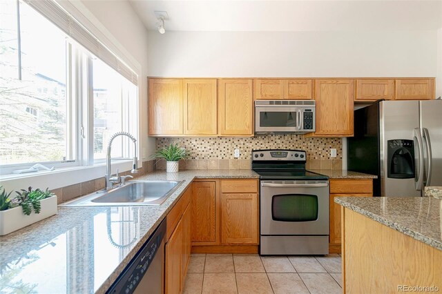2800 Aurora Ave Unit 121, Boulder, CO 80303 - kitchen featuring stainless steel appliances, decorative backsplash, light tile patterned floors, and light stone counters