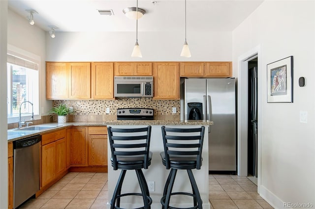 2800 Aurora Ave Unit 121, Boulder, CO 80303 - kitchen featuring appliances with stainless steel finishes, light tile patterned flooring, decorative backsplash, and pendant lighting