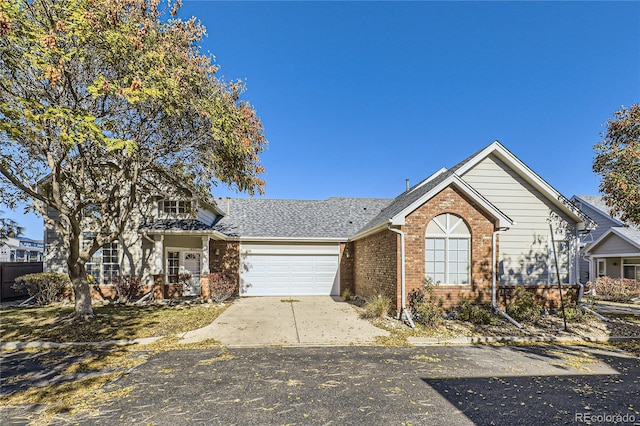 view of front of property with brick siding, an attached garage, concrete driveway, and a shingled roof