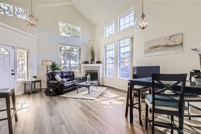 dining area featuring hardwood / wood-style flooring, plenty of natural light, a notable chandelier, and a fireplace