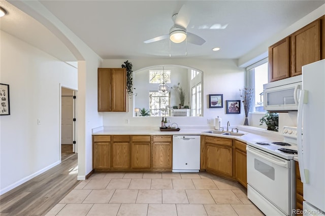 kitchen with ceiling fan with notable chandelier, sink, and white appliances