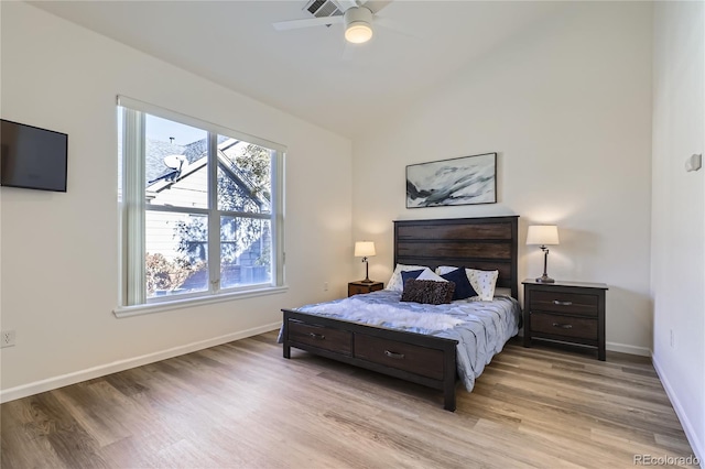 bedroom featuring ceiling fan, light hardwood / wood-style floors, and vaulted ceiling