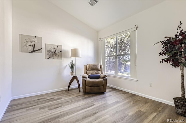 sitting room with lofted ceiling, a healthy amount of sunlight, and wood-type flooring