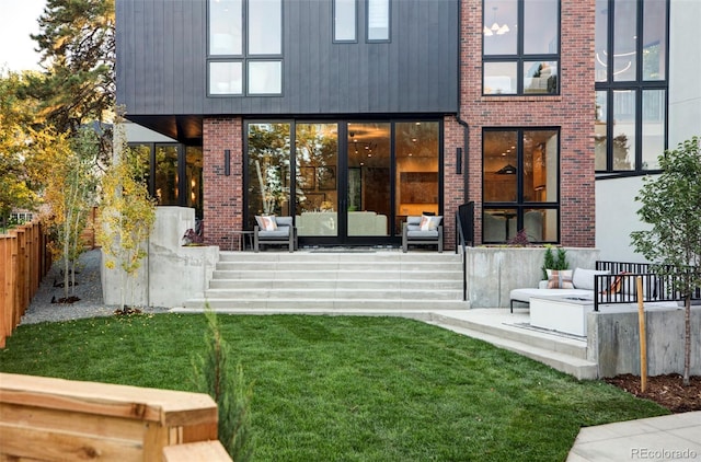 back of property featuring a yard and an outdoor hangout area