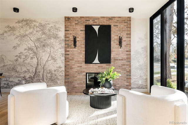 living room with hardwood / wood-style flooring and a brick fireplace