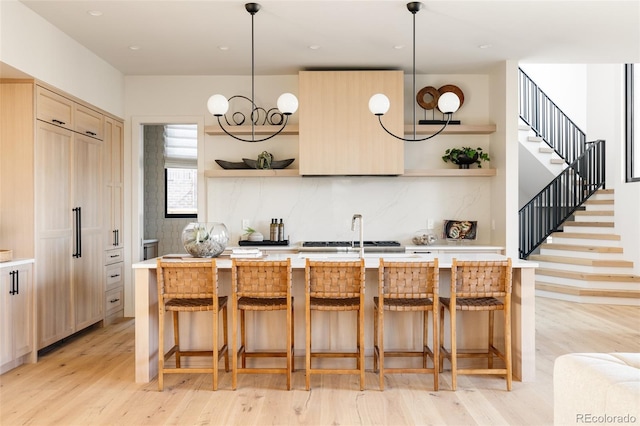 kitchen with pendant lighting, a breakfast bar, and light hardwood / wood-style flooring