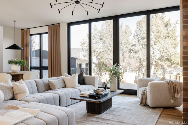 living room featuring a chandelier, expansive windows, and wood-type flooring