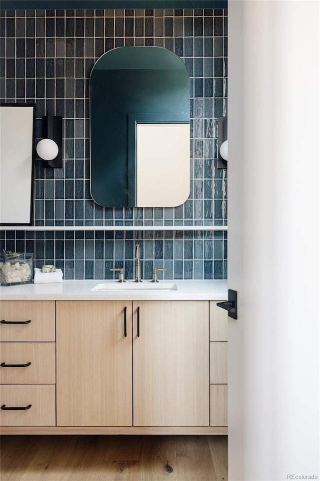 bathroom featuring decorative backsplash, vanity, and hardwood / wood-style flooring