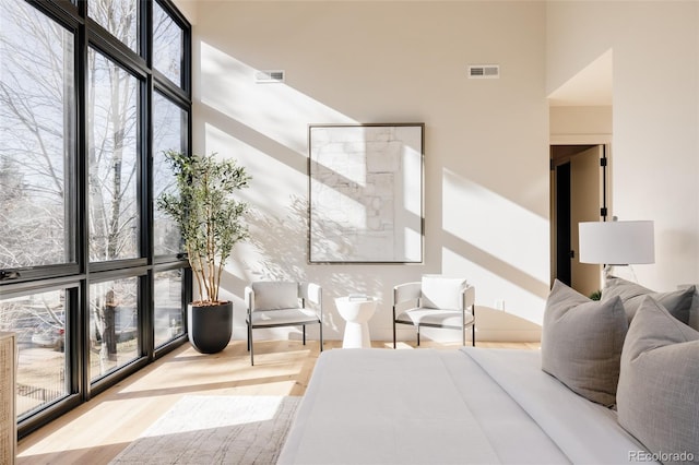 bedroom featuring a high ceiling and light hardwood / wood-style flooring