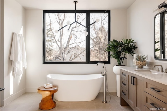 bathroom featuring a tub to relax in, tile patterned flooring, and vanity