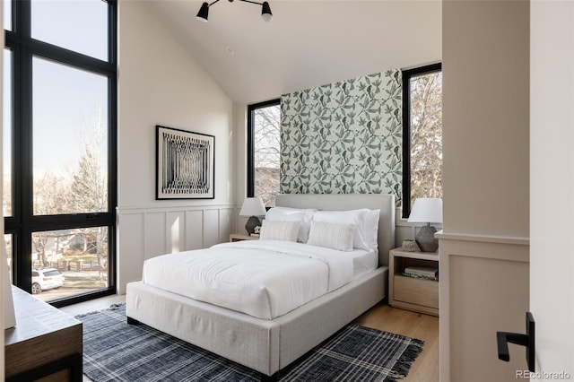 bedroom with hardwood / wood-style floors and high vaulted ceiling