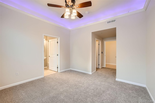 unfurnished room with crown molding, light colored carpet, visible vents, ceiling fan, and baseboards