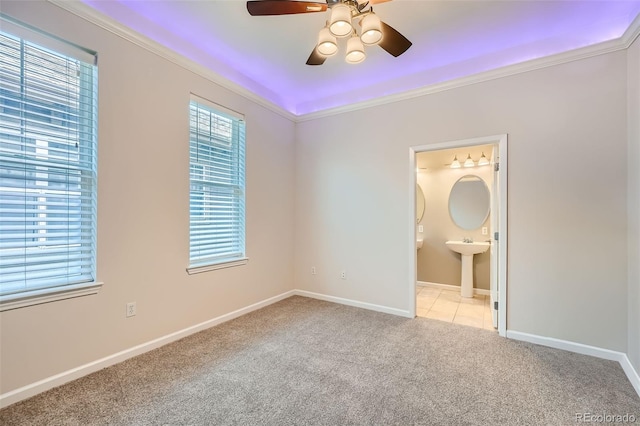 unfurnished bedroom featuring multiple windows, baseboards, crown molding, and light colored carpet