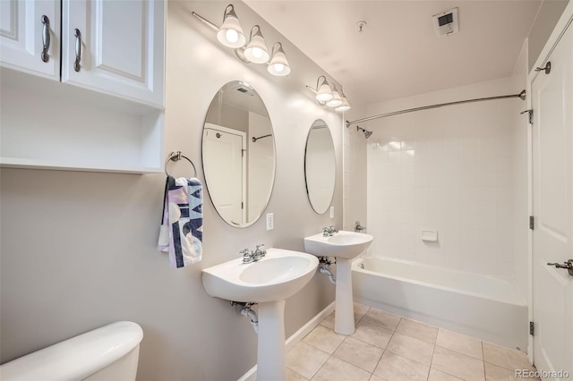 full bathroom featuring two sinks, toilet, shower / bath combination, visible vents, and tile patterned floors