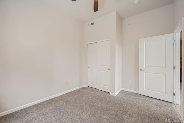 unfurnished bedroom with baseboards, visible vents, a ceiling fan, light colored carpet, and a closet