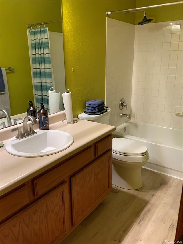 full bathroom with wood-type flooring, vanity, shower / tub combo, and toilet