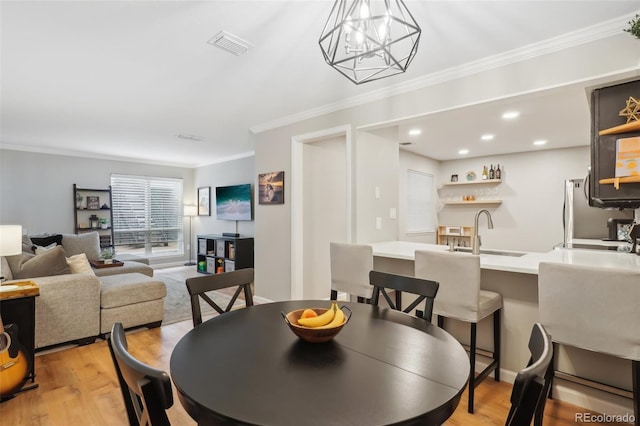 dining room with recessed lighting, visible vents, light wood-style flooring, and ornamental molding