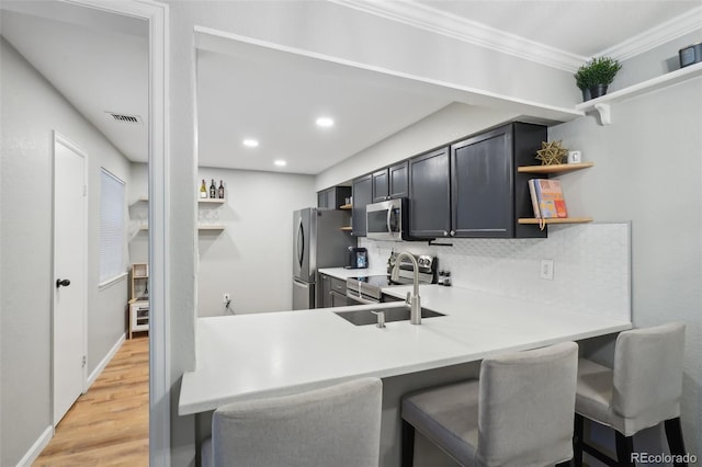 kitchen featuring visible vents, open shelves, a sink, appliances with stainless steel finishes, and decorative backsplash