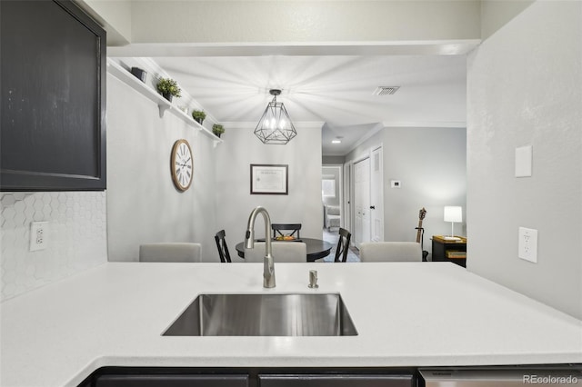 kitchen featuring a sink, ornamental molding, and light countertops