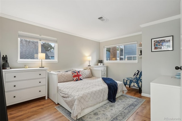 bedroom with visible vents, multiple windows, ornamental molding, and light wood finished floors