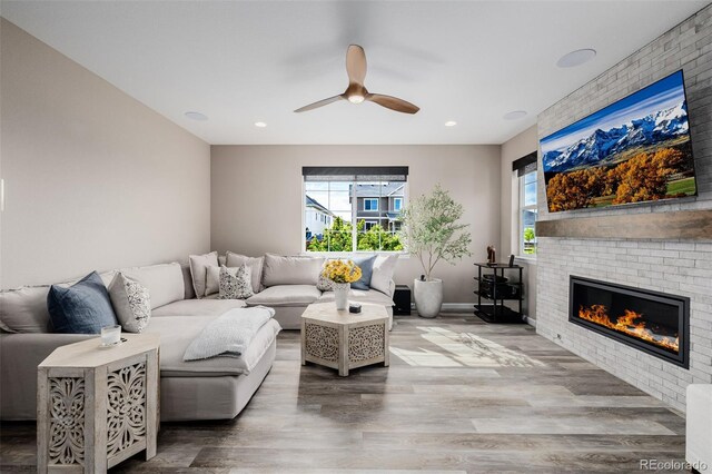 3059 Morningbird Ln, Castle Rock, CO 80109 - living area featuring a brick fireplace, plenty of natural light, ceiling fan, wood finished floors, and recessed lighting