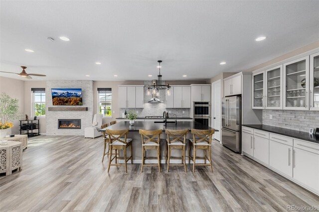 3059 Morningbird Ln, Castle Rock, CO 80109 - kitchen with appliances with stainless steel finishes, dark countertops, decorative backsplash, a kitchen breakfast bar, and recessed lighting