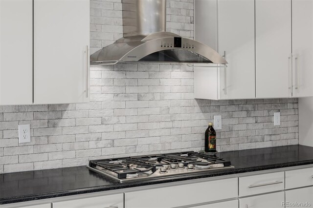3059 Morningbird Ln, Castle Rock, CO 80109 - kitchen featuring wall chimney exhaust hood, stainless steel gas stovetop, backsplash, and white cabinetry