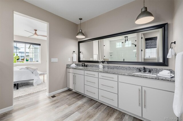 3059 Morningbird Ln, Castle Rock, CO 80109 - ensuite bathroom featuring a shower stall, double vanity, wood finished floors, baseboards, and a ceiling fan