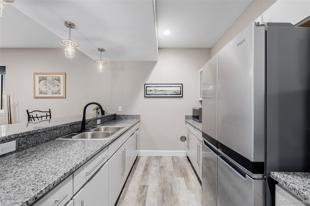 3059 Morningbird Ln, Castle Rock, CO 80109 - kitchen with appliances with stainless steel finishes, a sink, light wood-style floors, white cabinets, and baseboards