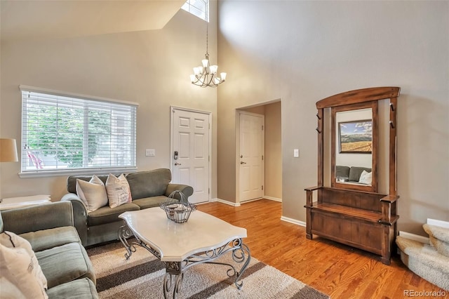 7472 S Memphis St, Aurora, CO 80016 - living area featuring a high ceiling, plenty of natural light, a chandelier, light wood-style flooring, and baseboards