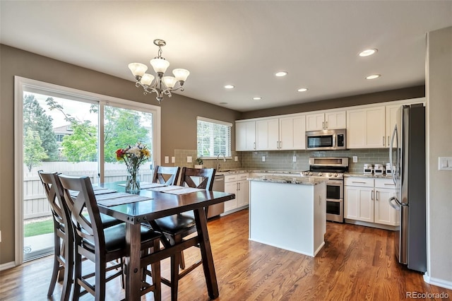 7472 S Memphis St, Aurora, CO 80016 - kitchen featuring stainless steel appliances, a chandelier, decorative backsplash, white cabinetry, and recessed lighting