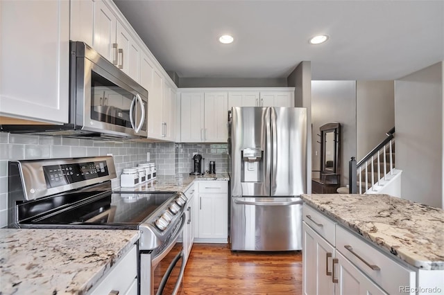 7472 S Memphis St, Aurora, CO 80016 - kitchen featuring appliances with stainless steel finishes, white cabinets, backsplash, recessed lighting, and light wood finished floors