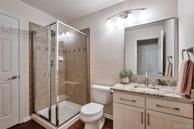 7472 S Memphis St, Aurora, CO 80016 - full bath featuring vanity, a stall shower, toilet, and wood finished floors