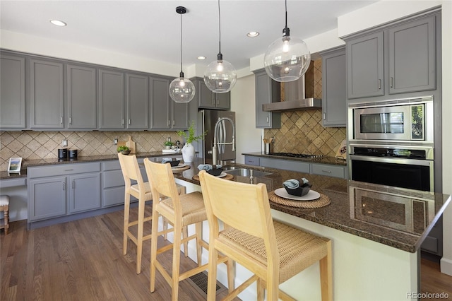 10109 E 28th Ave, Denver, CO 80238 - kitchen featuring stainless steel appliances, gray cabinets, tasteful backsplash, a kitchen breakfast bar, and recessed lighting
