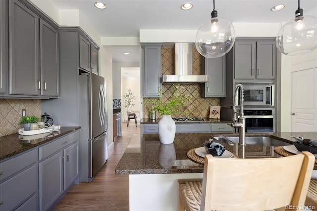 10109 E 28th Ave, Denver, CO 80238 - kitchen with stainless steel appliances, wall chimney range hood, backsplash, gray cabinetry, and recessed lighting