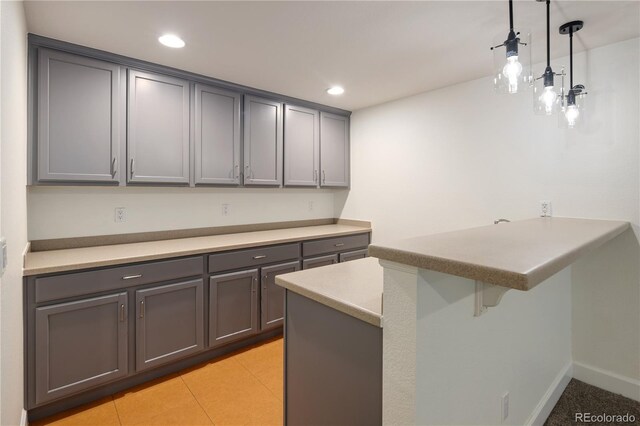 10109 E 28th Ave, Denver, CO 80238 - kitchen with gray cabinetry, a peninsula, a kitchen bar, pendant lighting, and recessed lighting