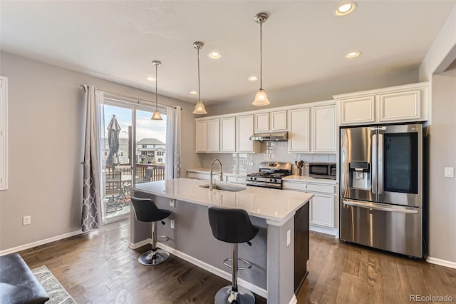 7360 S Old Hammer Way, Aurora, CO 80016 - kitchen featuring appliances with stainless steel finishes, dark wood-type flooring, light countertops, a center island with sink, and recessed lighting