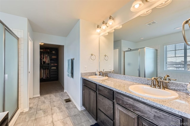7360 S Old Hammer Way, Aurora, CO 80016 - bathroom featuring a shower stall, double vanity, and a walk in closet