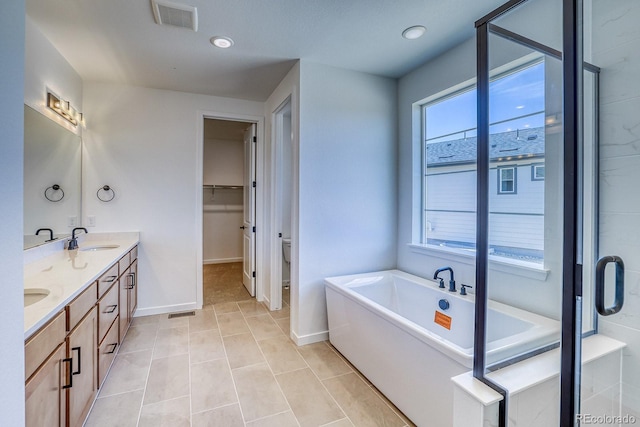 23738 E 42nd Ave, Aurora, CO 80019 - full bath with double vanity, a freestanding tub, tile patterned flooring, recessed lighting, and a walk in closet