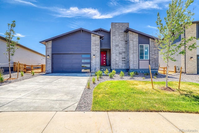 23738 E 42nd Ave, Aurora, CO 80019 - view of front of home with a garage, concrete driveway, and stone siding
