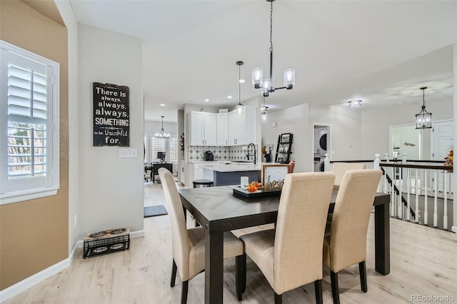 dining space with a chandelier, sink, and light hardwood / wood-style floors