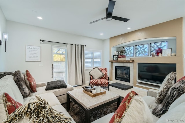 living room with a tile fireplace, ceiling fan, and hardwood / wood-style floors