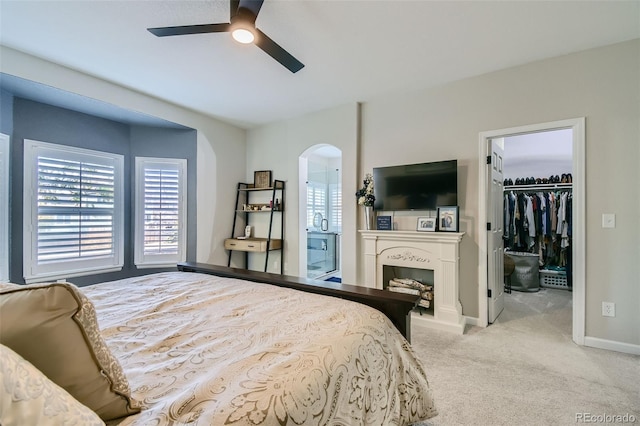 carpeted bedroom featuring ceiling fan, a spacious closet, and a closet