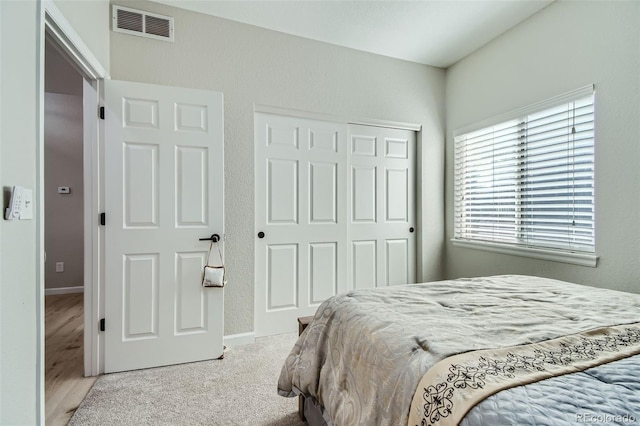 bedroom with light carpet and a closet