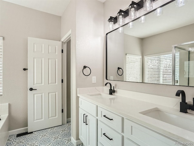 bathroom featuring tile patterned floors, vanity, and a bath