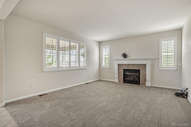 10272 Greenfield Cir, Parker, CO 80134 - unfurnished living room featuring a high end fireplace, baseboards, and carpet