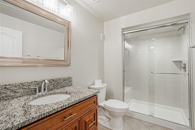 10272 Greenfield Cir, Parker, CO 80134 - bathroom with a shower stall, toilet, tile patterned floors, and vanity
