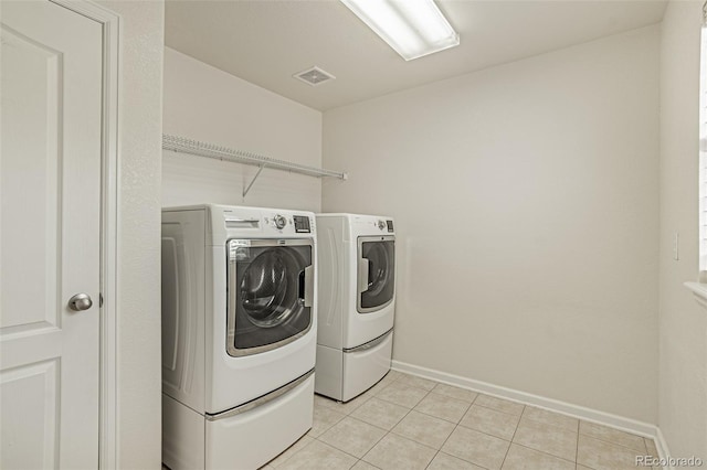 10272 Greenfield Cir, Parker, CO 80134 - laundry area with washer and clothes dryer, baseboards, and light tile patterned flooring